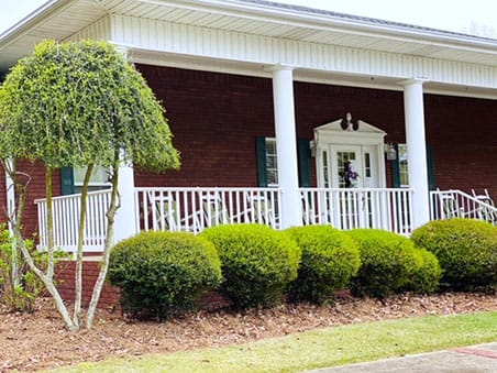 Exterior view of a nursing home entrance with greenery
