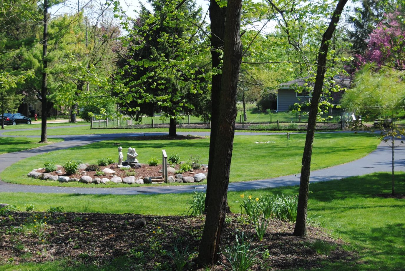 Fairhaven Corporation, Nursing Home in Whitewater, WI — Scenic garden pathway surrounded by trees and greenery