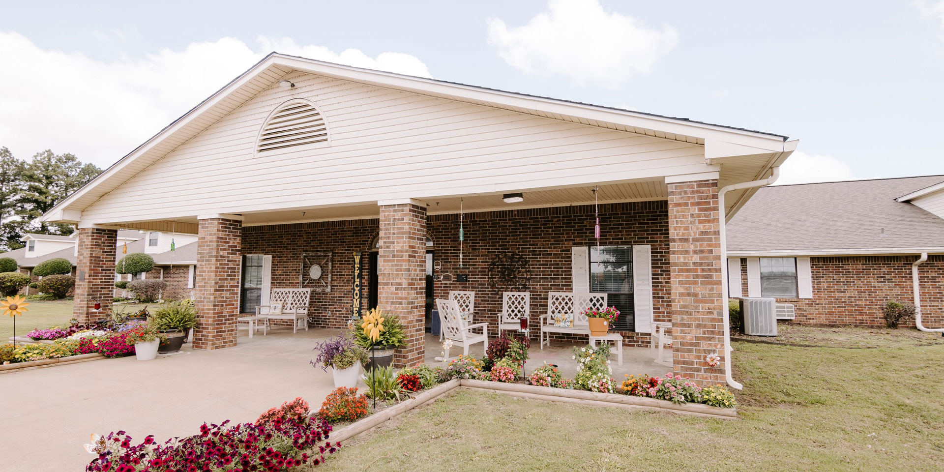 Exterior view of a welcoming entrance with flower beds