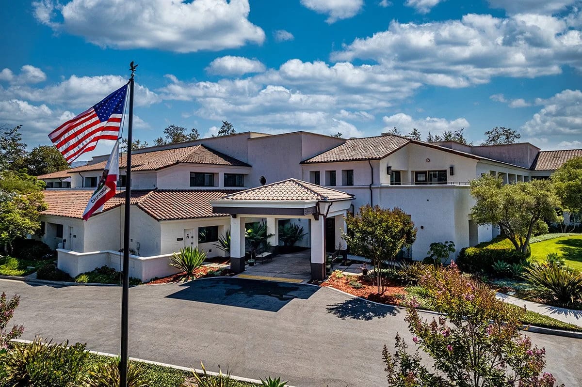 Exterior view of Granvida Senior Living facility with flag