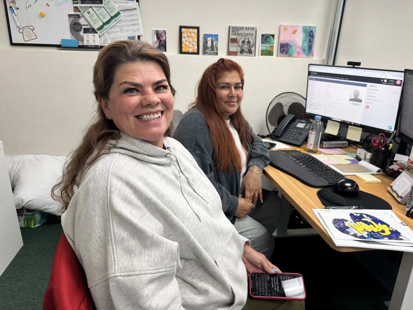 Two staff members smiling in an office environment