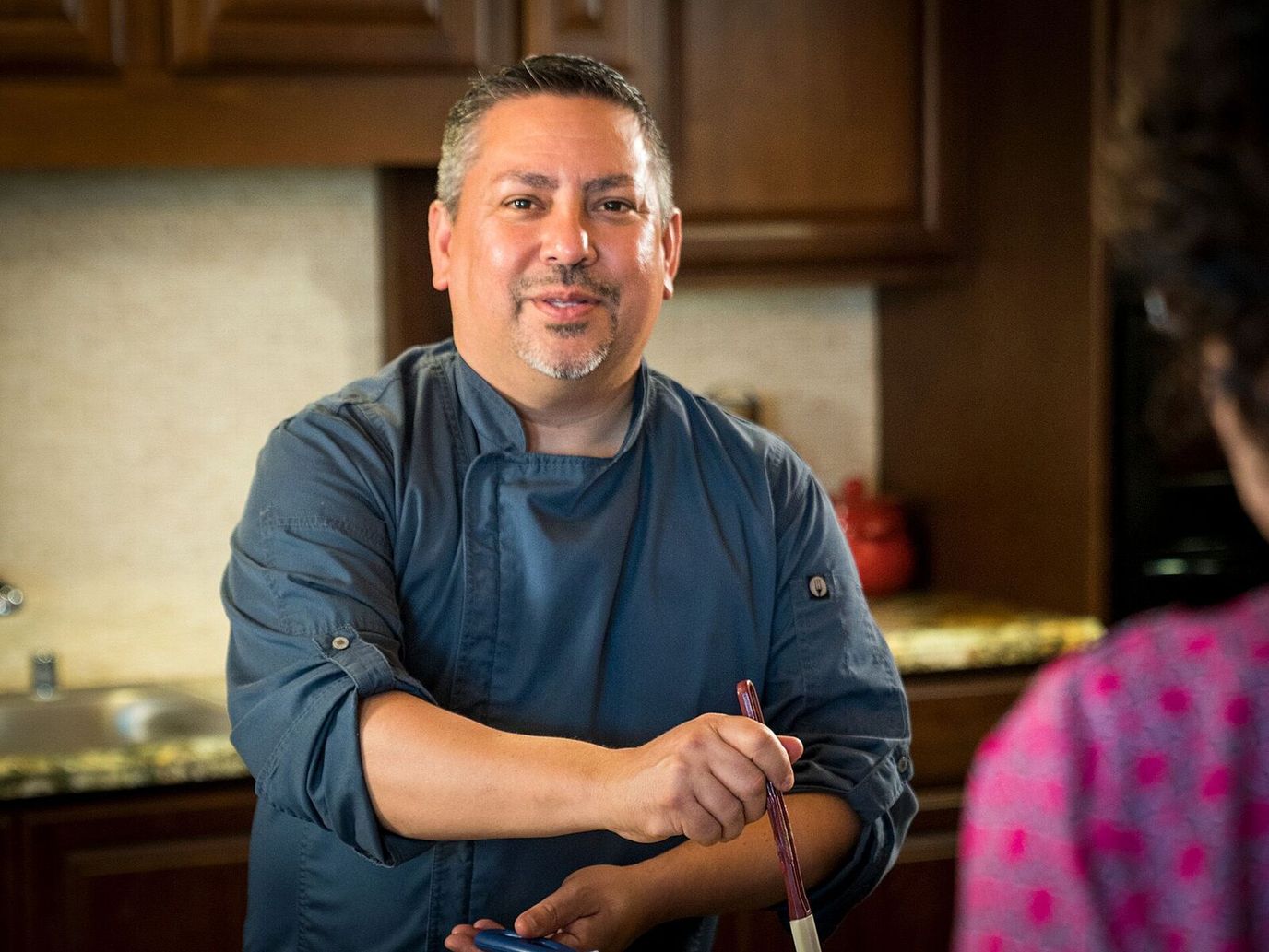 Chef interacting with a resident in a kitchen setting