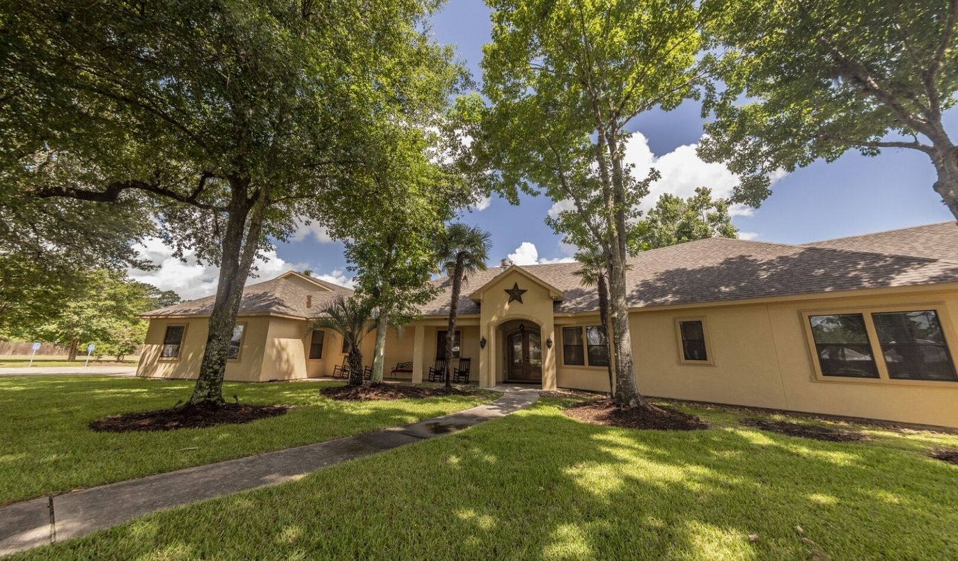 Exterior view of a senior living facility surrounded by trees