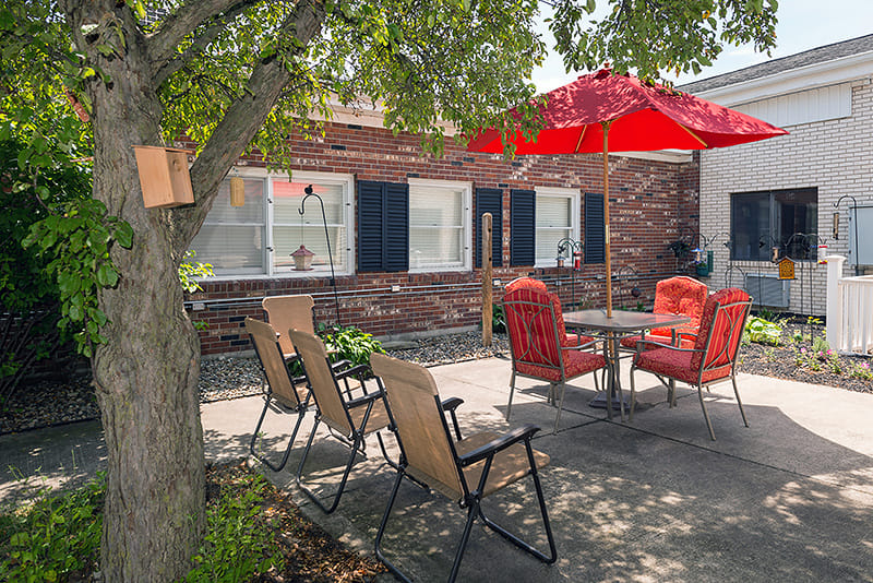 Outdoor seating area with red umbrella and chairs