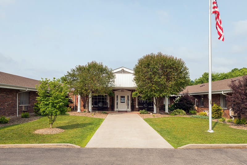 Front entrance of a senior living facility with landscaped grounds