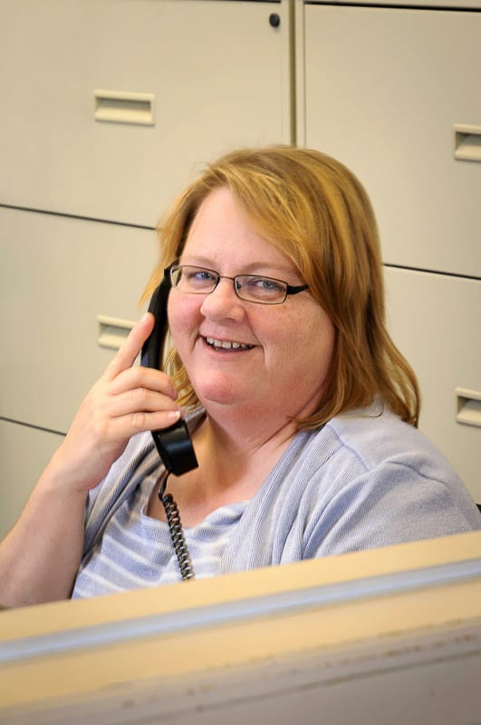 Staff member talking on the phone at a reception desk