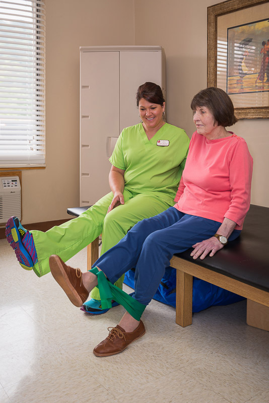 Therapist assisting resident with exercises in a bright room