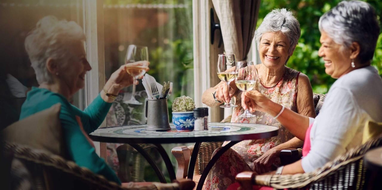 MorseLife Health System, nursing home in West Palm Beach, FL — Seniors enjoying a toast on a sunny patio