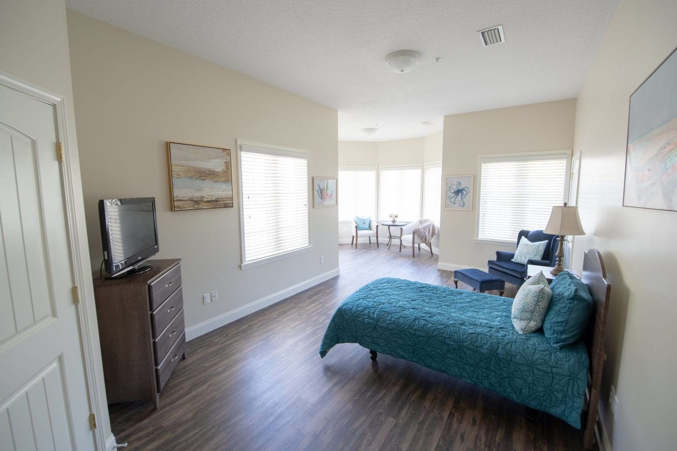 A spacious and well-lit resident room with furnishings