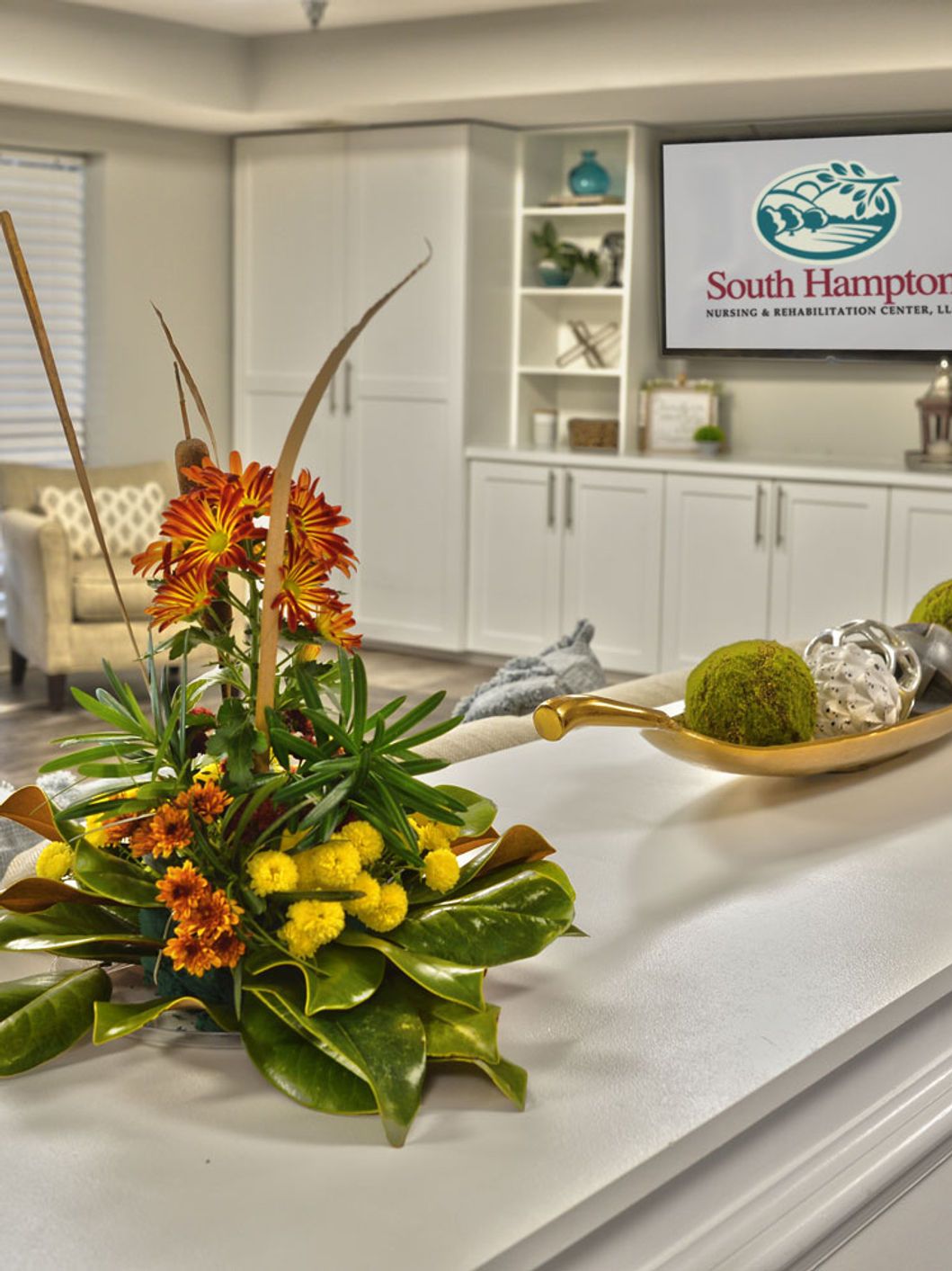 South Hampton Nursing & Rehabilitation Center, Nursing Home in Owens Cross Roads, AL — Floral arrangement on a reception desk with decorative elements