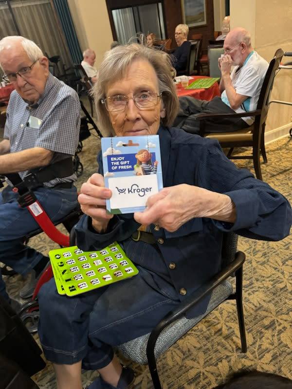 Woodland Heights, assisted living in Little Rock, AR — Resident holding a Kroger gift card in activity room