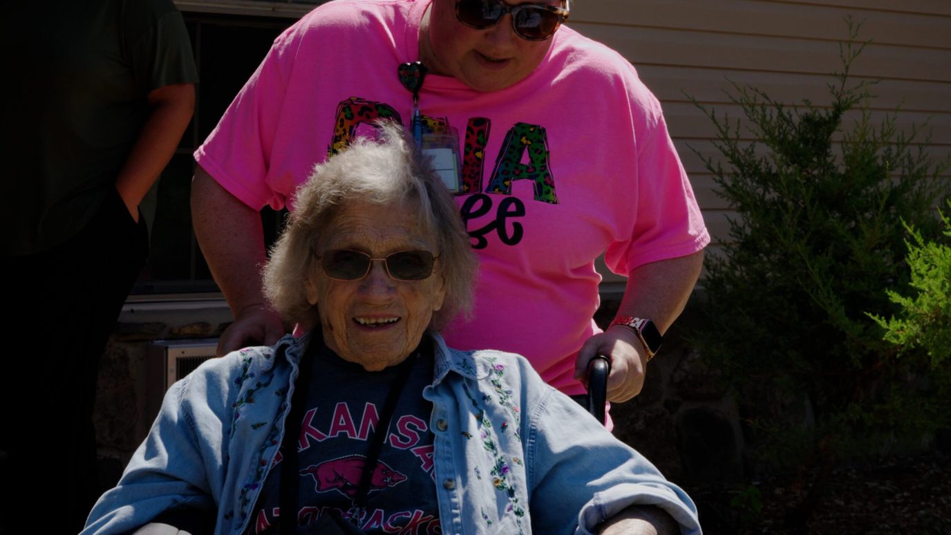Resident smiling while being assisted outdoors