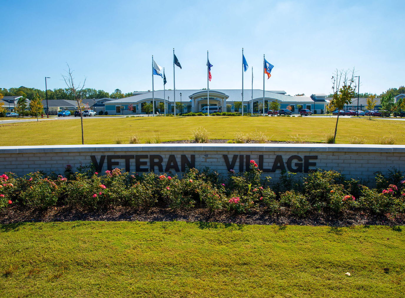 Exterior view of Veteran Village with flags and landscaping