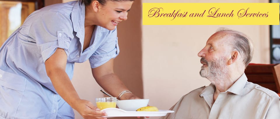 Caregiver serving breakfast to a resident