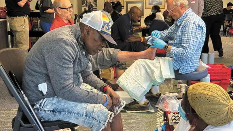Residents receiving foot care in a common area