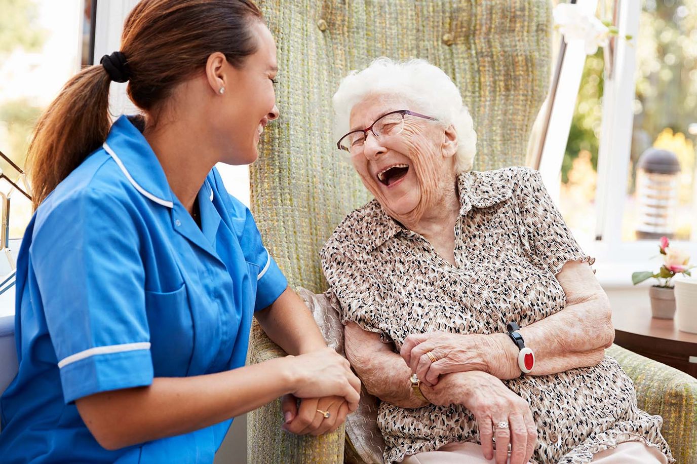 Caregiver interacting joyfully with an elderly resident
