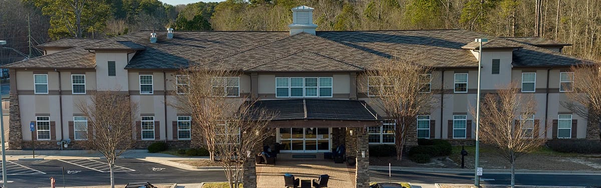 Exterior view of Ivy Springs Senior Living facility with trees