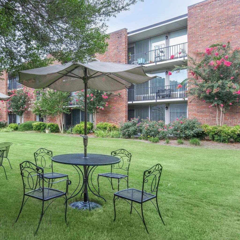 Outdoor seating area with tables and umbrellas.