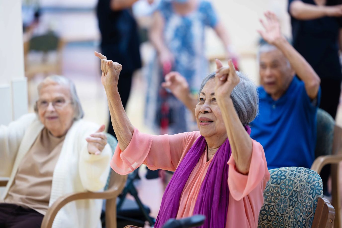 Residents engaged in an activity with staff in a bright common area