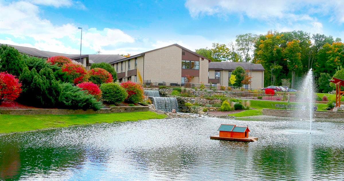 Scenic view of the facility with a pond and gardens