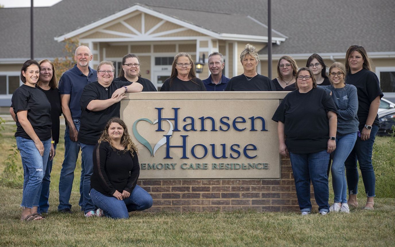 Staff members posing with the facility sign
