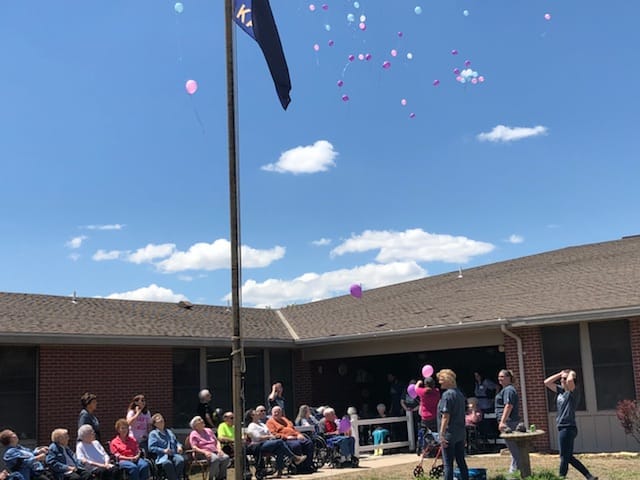 Residents celebrating outdoors with balloons