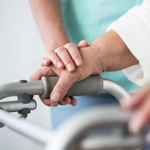 Closer view of hands holding a walker