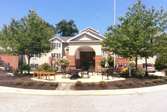 Exterior view of a senior living facility with outdoor seating