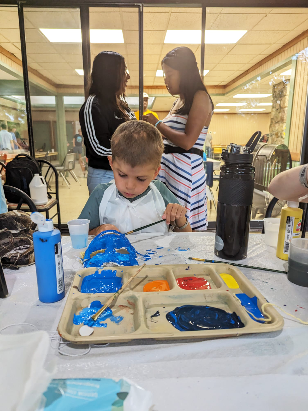 Children painting during an activity in a common area