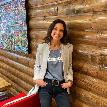 Woman standing in a cozy interior with wooden walls