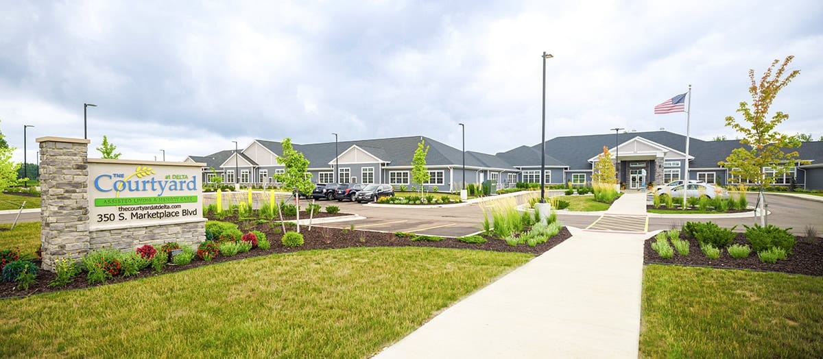 Exterior view of The Courtyard at Delta with gardens and pathway