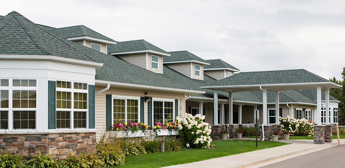 Exterior view of a senior living facility with flower beds