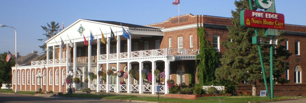 Exterior view of Nouis Home Care facility with flags
