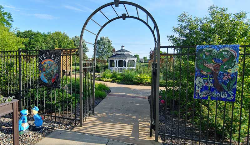 Garden entrance with artistic displays and gazebo in the background
