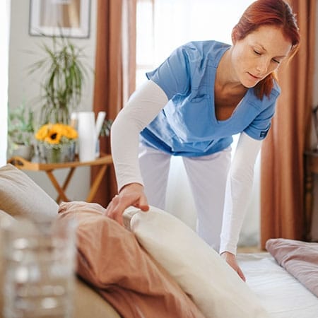 Mountainside of Warm Springs, assisted living in Warm Springs, GA — Caregiver making a bed in a cozy room