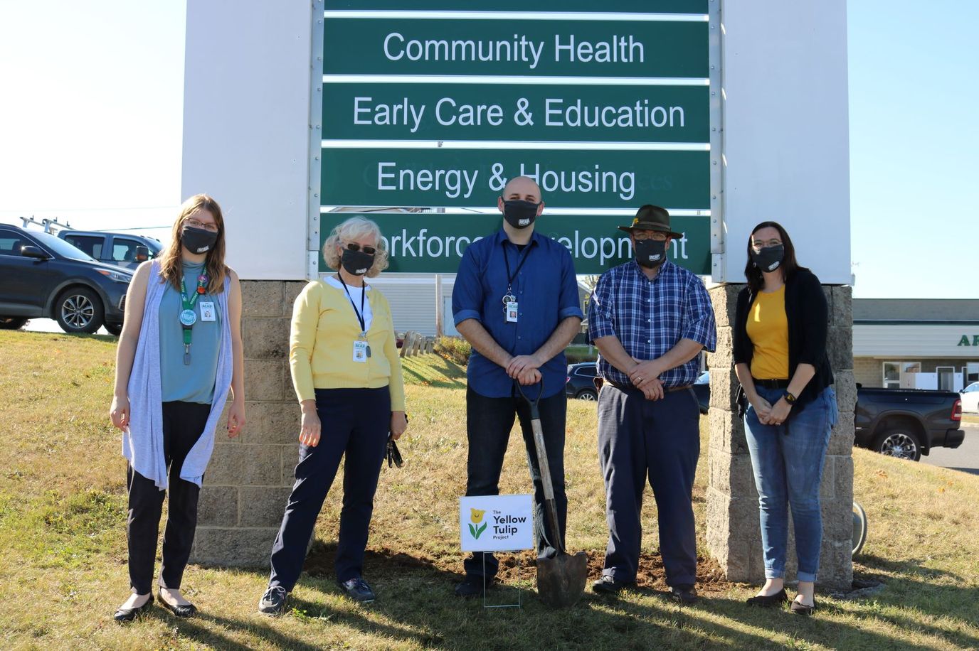 Group of people at a community health sign