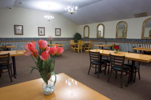 Bright dining room with flowers and tables.