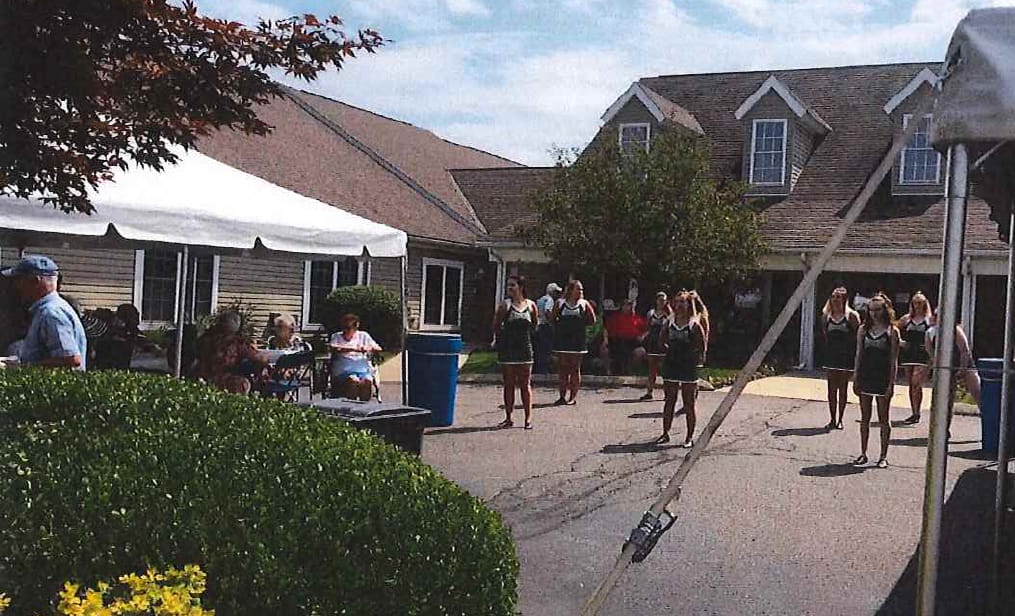 Outdoor celebration with residents and performers.
