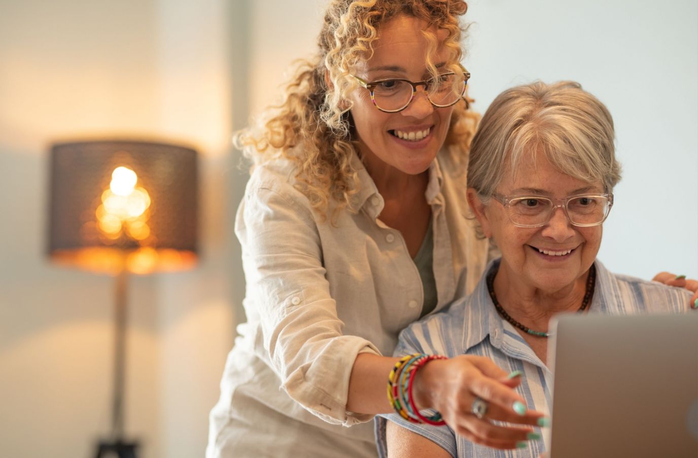 Senior woman and caregiver using a laptop together