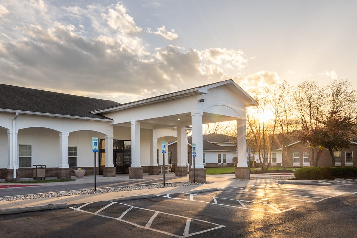 Front entrance of Jackson Creek Memory Care building at sunset