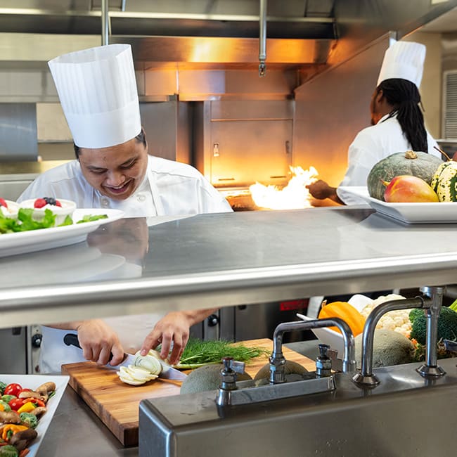 Chefs preparing food in a facility kitchen