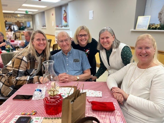 Residents and staff smiling together in a common area