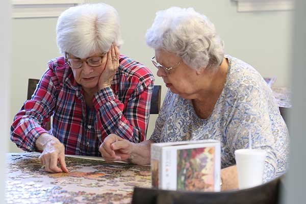 Two residents working on a jigsaw puzzle together