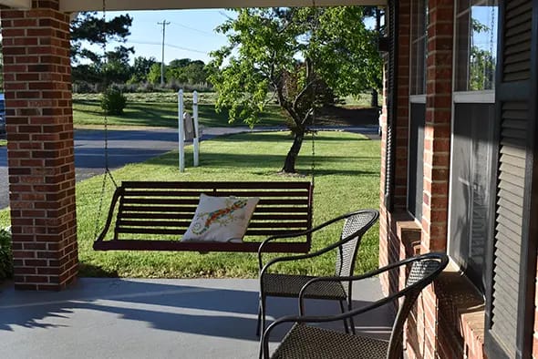 Swing on a porch overlooking a well-maintained lawn