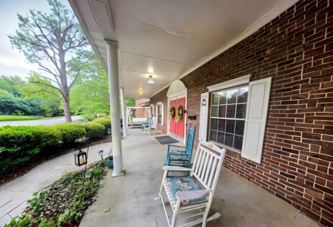 Rocking chairs on a covered porch outside