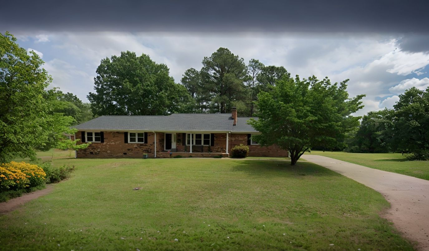 Exterior view of a residential facility with green grass and trees