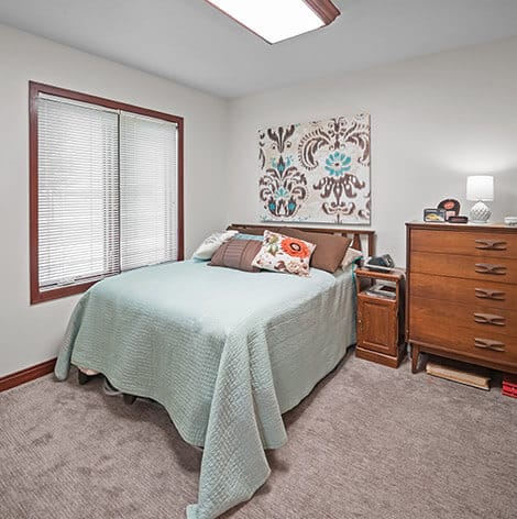 Good Samaritan Society – Grand Island Village, nursing home in Grand Island, NE — Cozy bedroom with a bed and dresser
