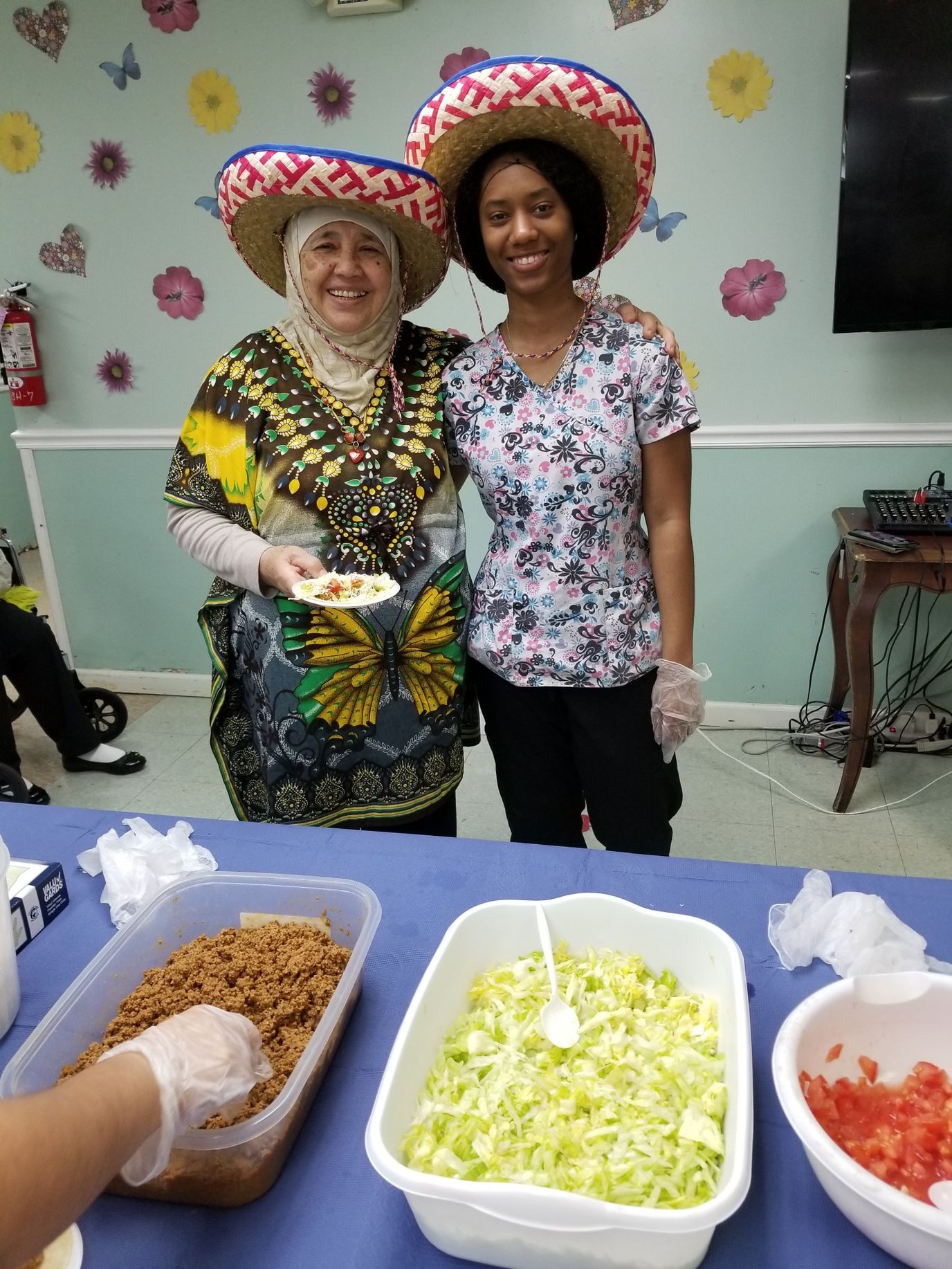 Residents and staff celebrating with food in colorful attire