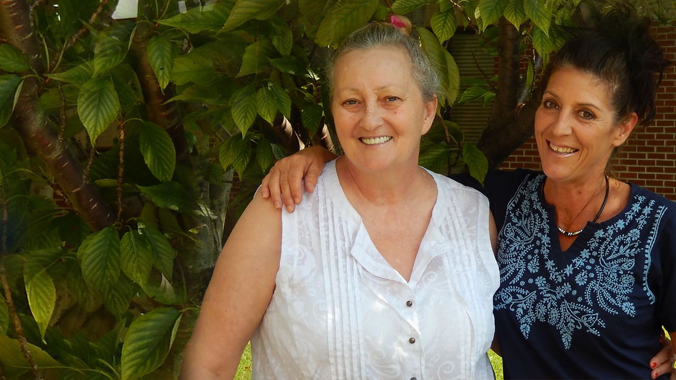Two women smiling in a garden setting