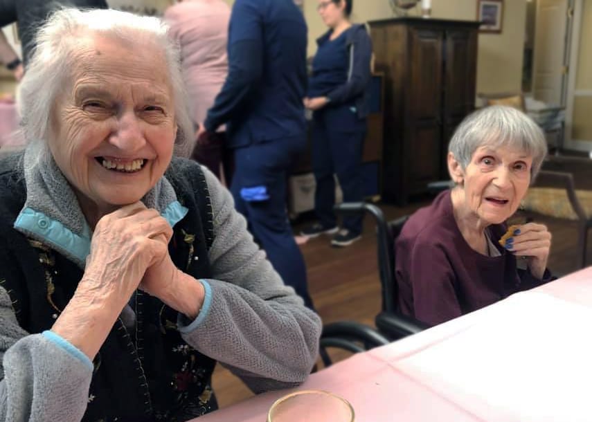 Two smiling residents enjoying time together indoors